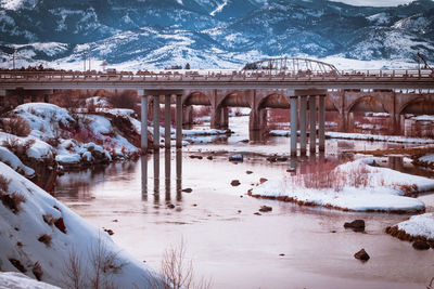 Bridge over river amidst snow covered land