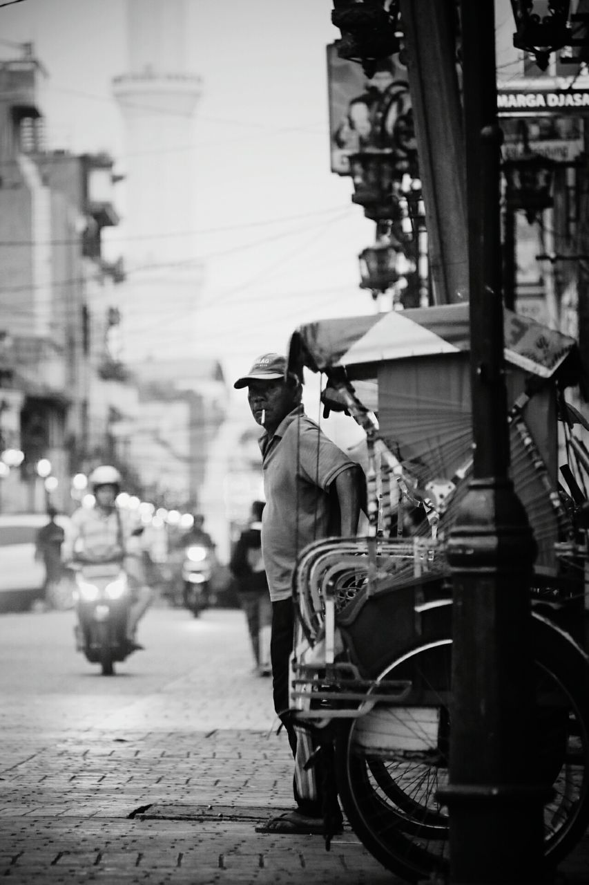 real people, street, transportation, mode of transport, land vehicle, building exterior, outdoors, built structure, rear view, men, walking, architecture, day, lifestyles, road, full length, city, motorcycle, bicycle, women, mammal, people