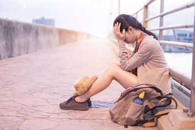 Full length of woman sitting outdoors