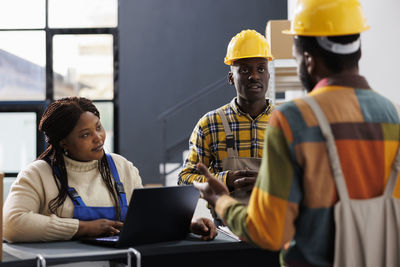 Rear view of people working in office