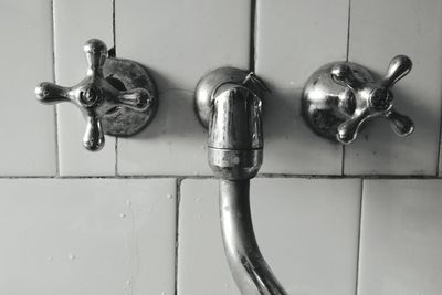 Close-up of faucet on white wall