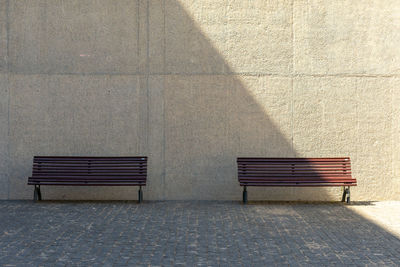 Empty bench against wall