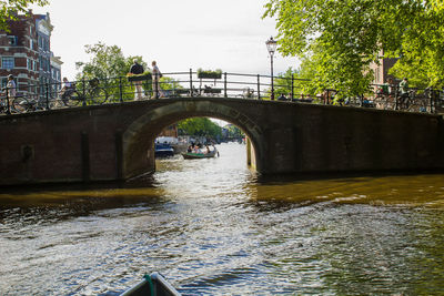 Bridge over river in city against sky