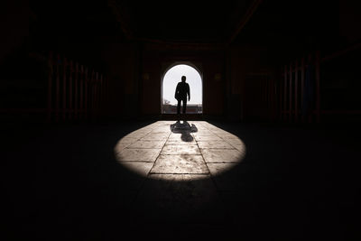 Silhouette man standing in corridor of building