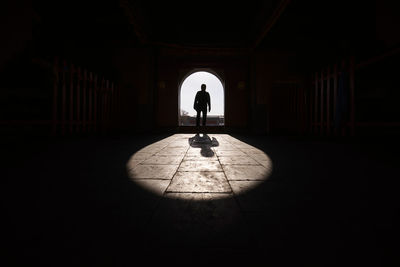 Silhouette man walking in corridor of building
