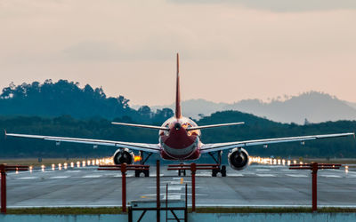 Airplane on runway against sky