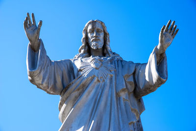 Low angle view of statue against blue sky