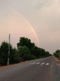 Scenic view of rainbow over street in city against sky