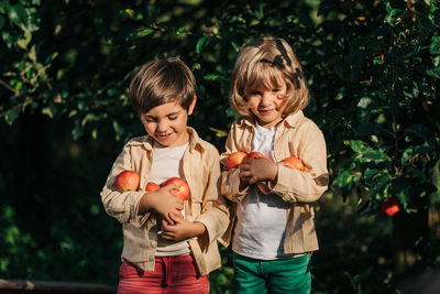 Portrait of siblings standing against plants