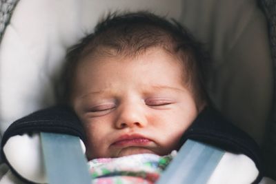 Close-up of cute baby girl sleeping on baby stroller 