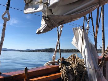 Sailboat hanging on pole by sea against sky