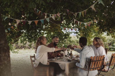 Rear view of people sitting on table