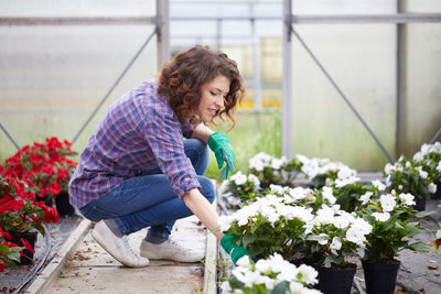 Woman taking care of plant in greenhouse