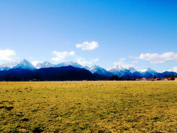 Scenic view of field and mountains against sky