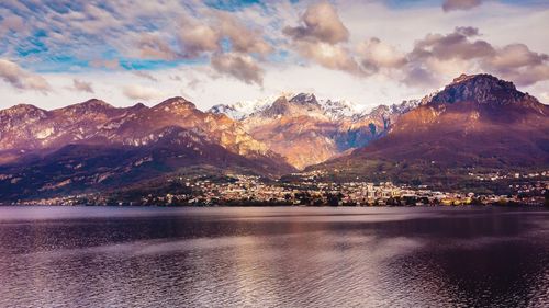 Scenic view of como lake by mountains against sky