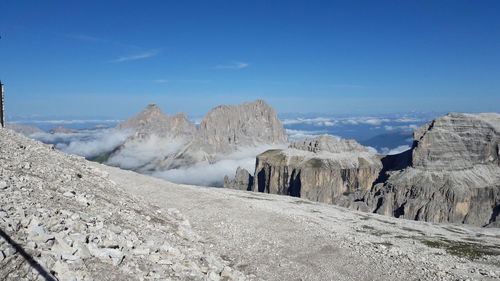 Panoramic view of rocky mountains against blue sky