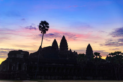 Silhouette of temple building against sky during sunset