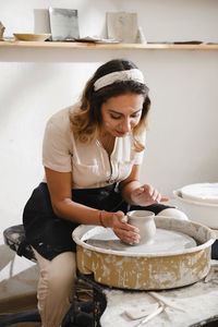 Potter making bowl on wheel. self-employed pottery artist in creative studio working with raw clay 