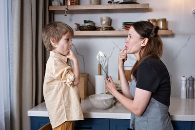 Family fun in the kitchen. mother and son baking carrot cake together. scandinavian kitchen interior