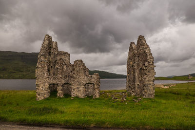 Stone structure on field against sky