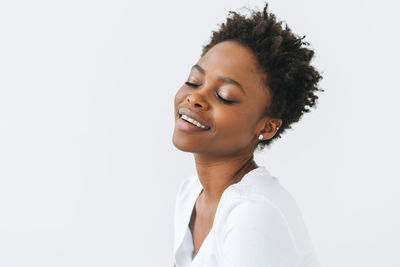 Portrait of happy young african american woman in white t-shirt isolated on white background