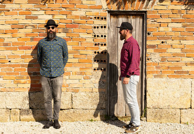 Men with beards in front of the wall