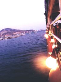 Cropped image of boat in sea at sunset