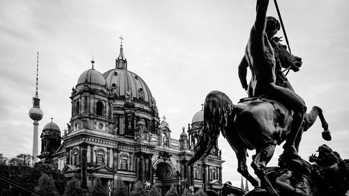 Low angle view of statue in city against sky