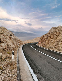 Empty road with with dividing line. rocky terrain, beautiful sky.