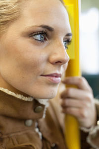 Thoughtful woman holding railing on bus