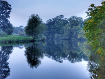 Reflection of trees in lake against sky