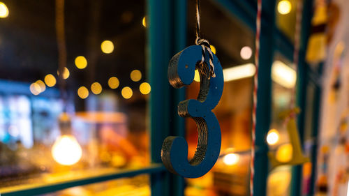 Close-up of illuminated lighting equipment hanging at night