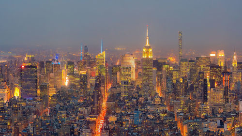 Illuminated cityscape against sky at night