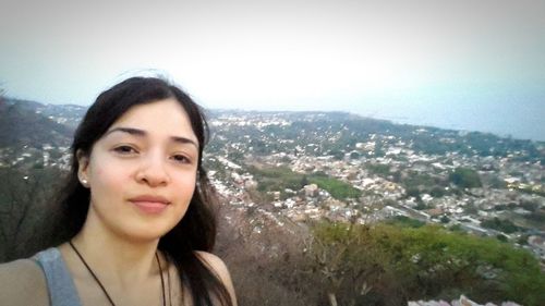 Portrait of smiling young woman against clear sky