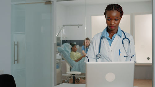 Female doctor using laptop at hospital