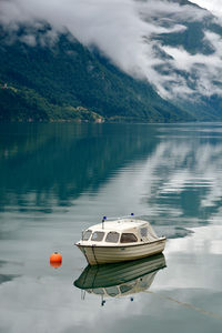 Boat moored in lake against sky