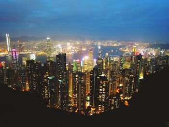 Illuminated cityscape against sky at night