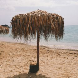 Thatched roof umbrella at beach on sunny day