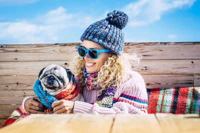 Portrait of young woman wearing sunglasses with dog outdoors