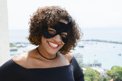 Young woman wearing mask against sky