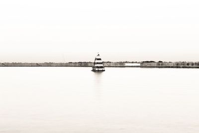 Sailboat sailing on sea against clear sky