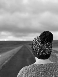 Rear view of woman on road against sky