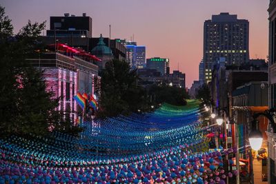 Crowd at illuminated city against sky at night