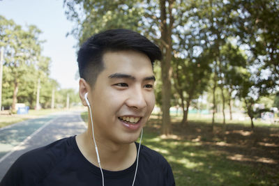 Portrait of smiling young man against trees