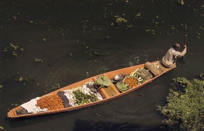 High angle view of man with vegetables in boat rowing on lake