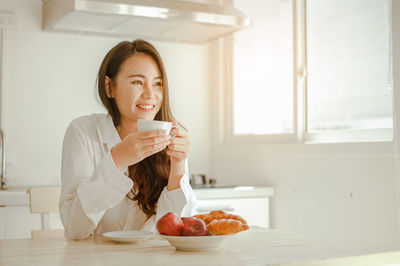 Portrait of young woman drinking coffee cup