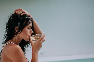 Portrait of a beautiful young woman drinking glass