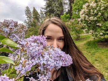 Portrait of young woman with purple flowers on tree