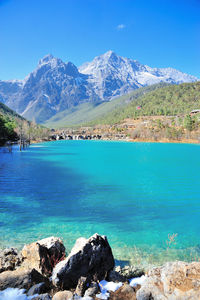 Scenic view of sea and mountains against blue sky