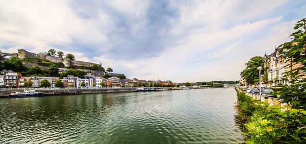 Scenic view of river by town against sky